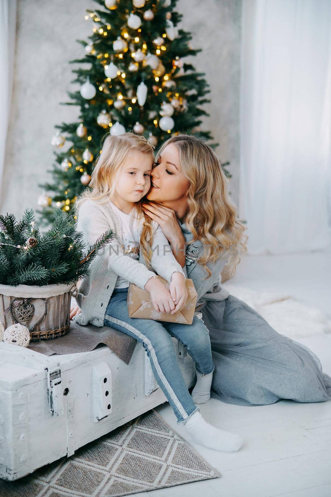 Happy family: mother and daughter. Family in a bright New Year's interior with a Christmas tree.