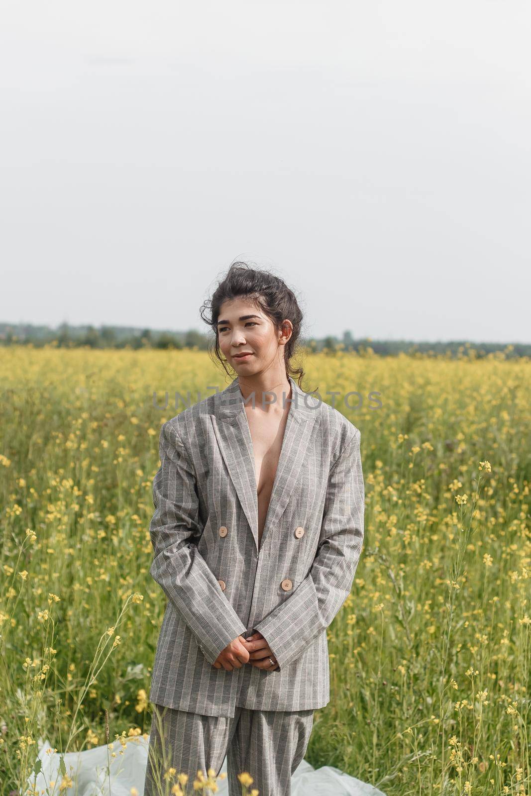 An Asian model poses in a field of yellow flowers for a clothing brand, polyethylene is the main props for a photo shoot. by Annu1tochka