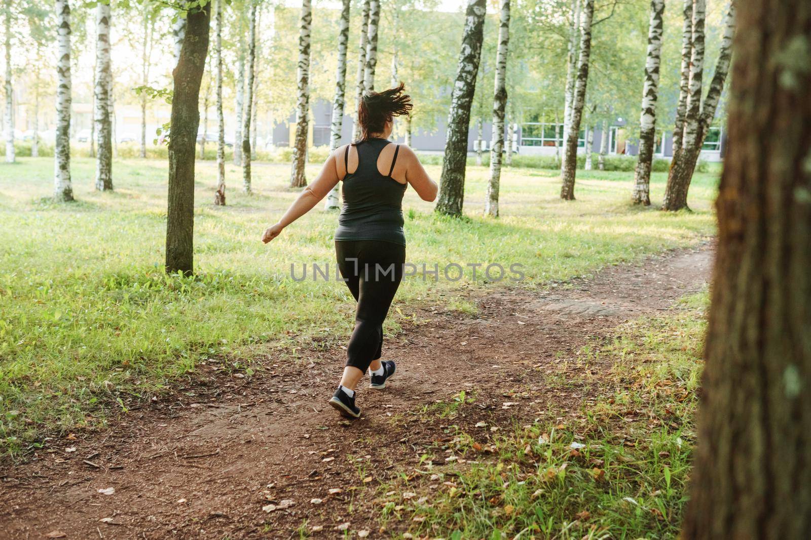 A charming brunette woman plus-size body positive practices sports in nature by Annu1tochka