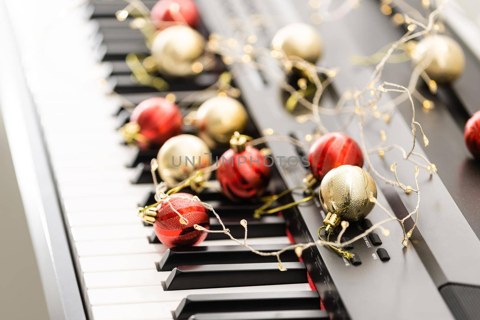 Piano keyboard with Christmas garland close up by Andelov13