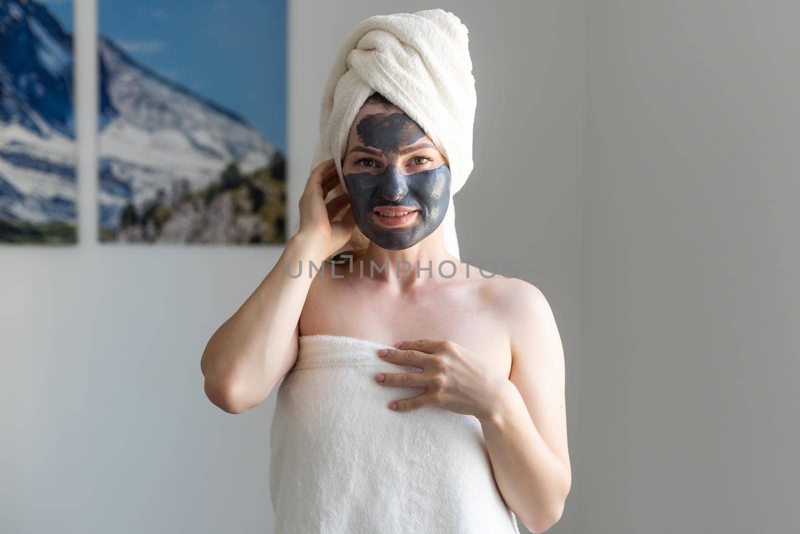 Beautiful woman applying facial mask on her face. Skin care and treatment, spa, natural beauty and cosmetology concept