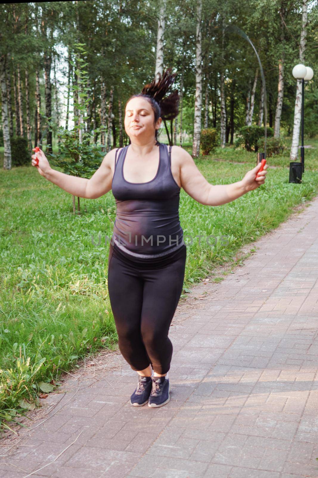 A charming brunette woman plus-size body positive practices sports in nature by Annu1tochka
