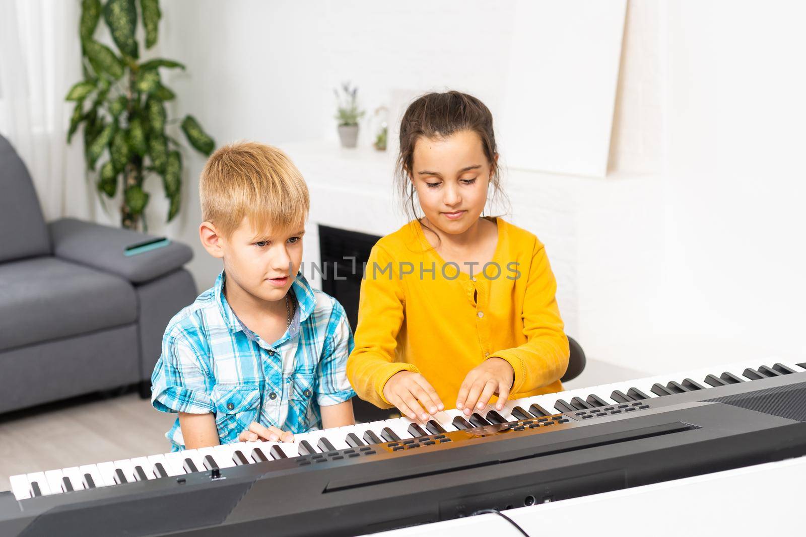 Brother and sister play the synthesizer. Children play at piano. family games.