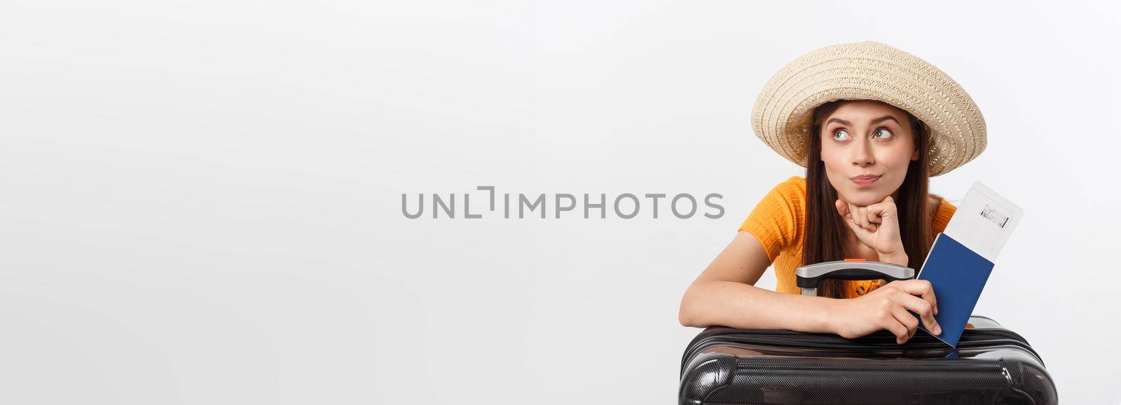 Travel concept. Studio portrait of pretty young woman holding passport and luggage. Isolated on white.