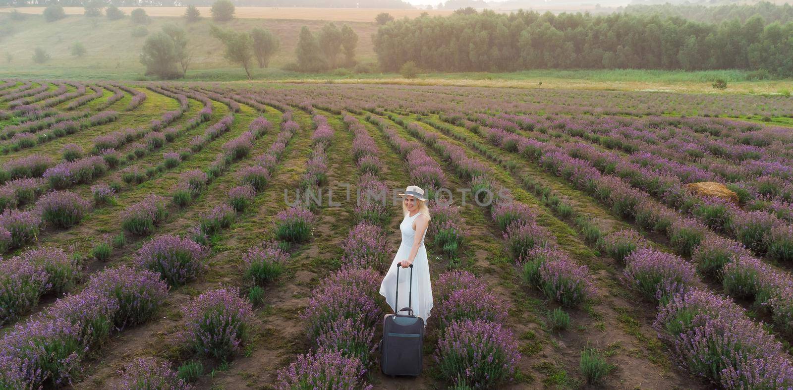 drone video of free and happy young woman run in pink and purple lavender fields at sunset by Andelov13