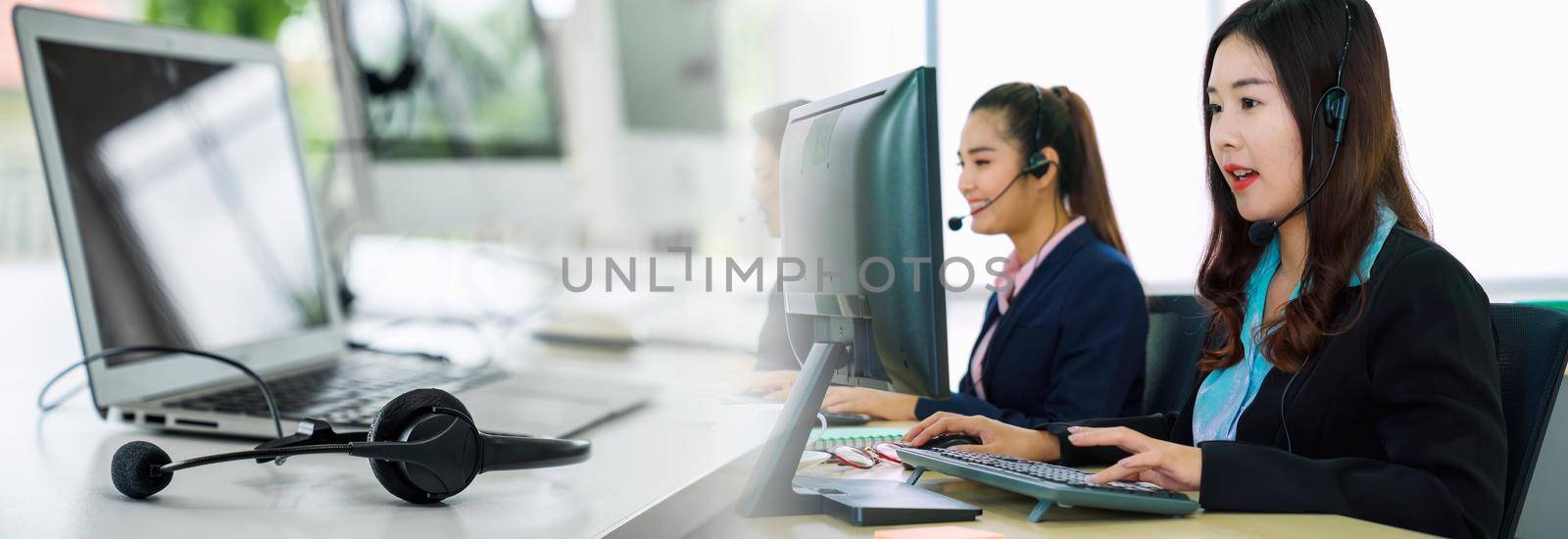 Business people wearing headset working in office in widen view to support remote customer or colleague. Call center, telemarketing, customer support agent provide service on telephone video call.