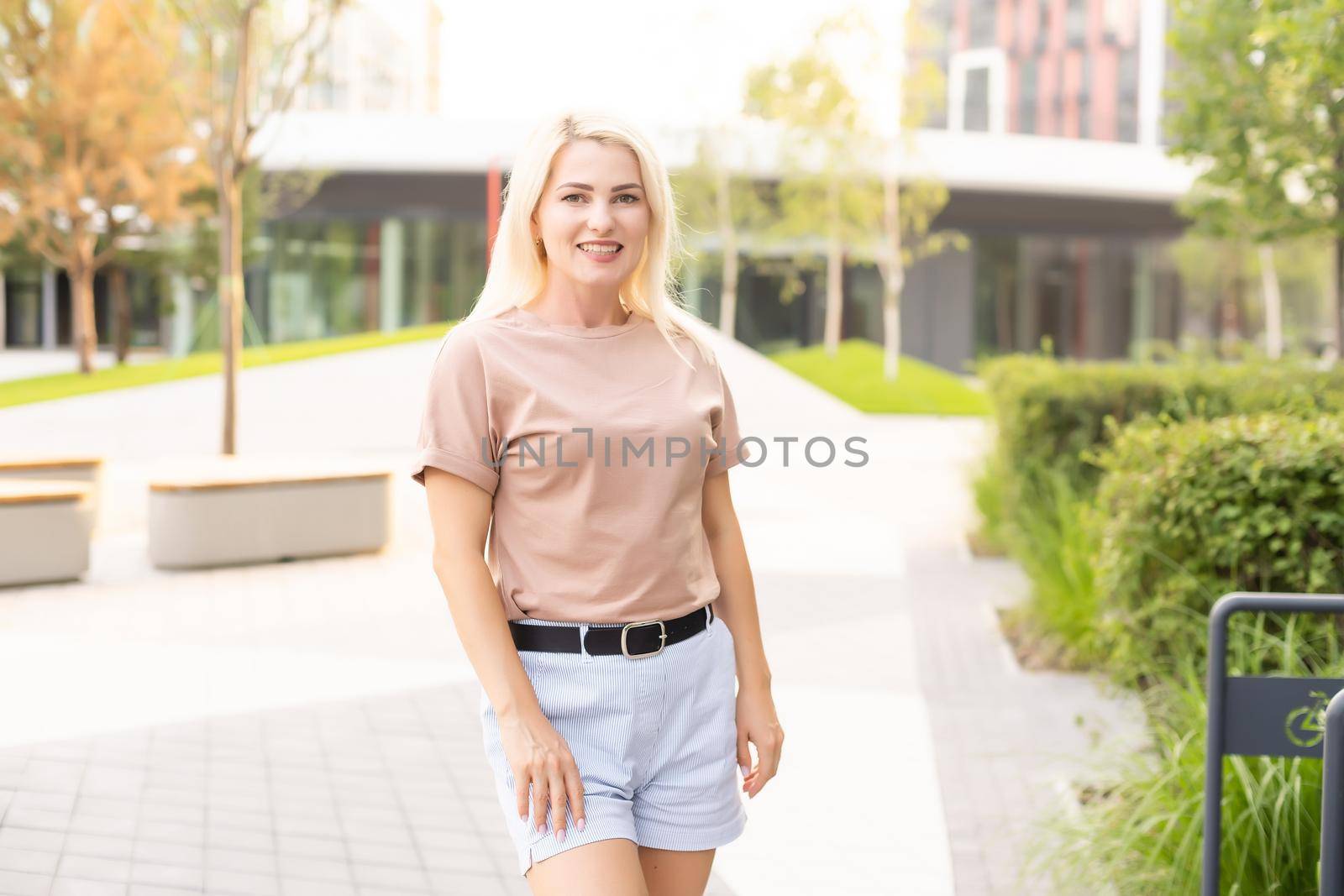 Portrait of young beautiful smiling hipster woman in trendy summer shorts. Sexy carefree model posing on the street background by Andelov13