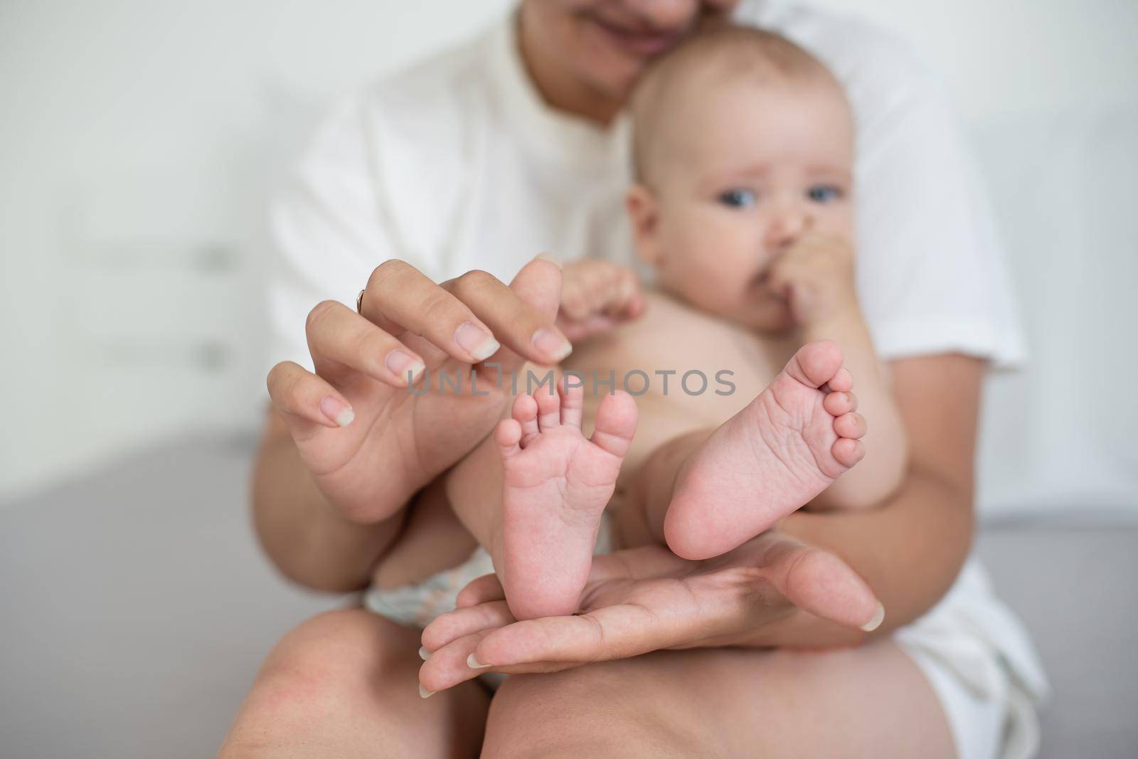 Happy smiling mother and baby lying on bed at home by Andelov13