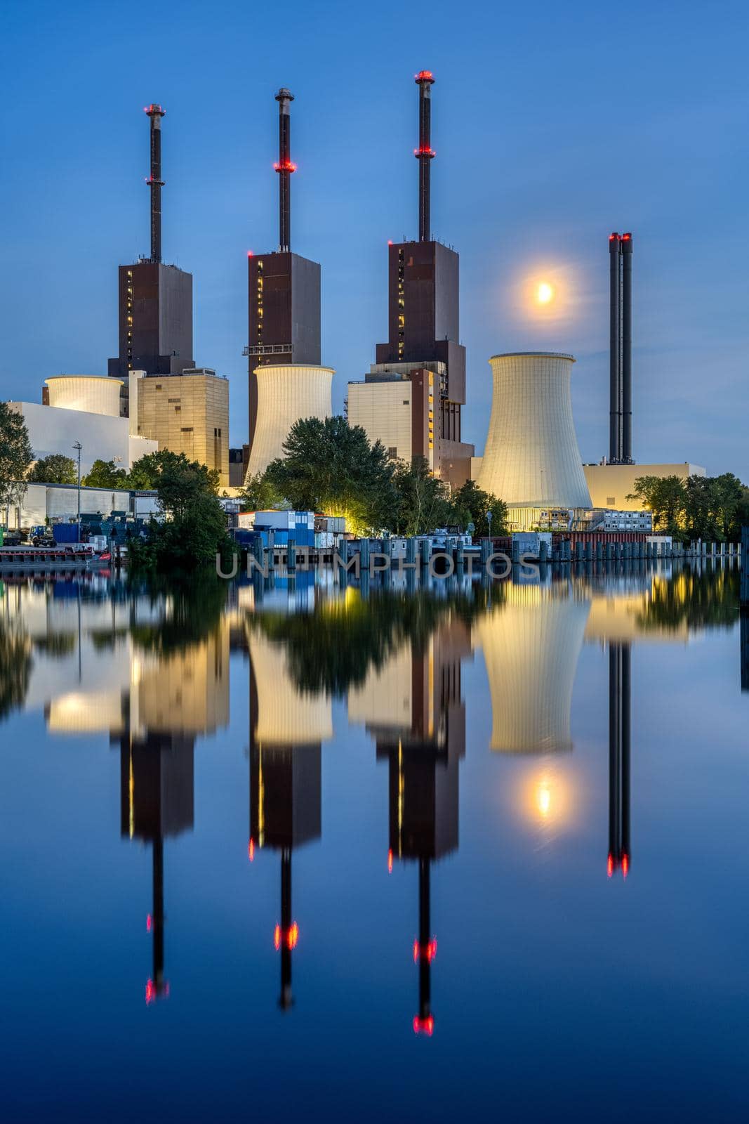 A thermal power station in Berlin at dusk reflected in a canal