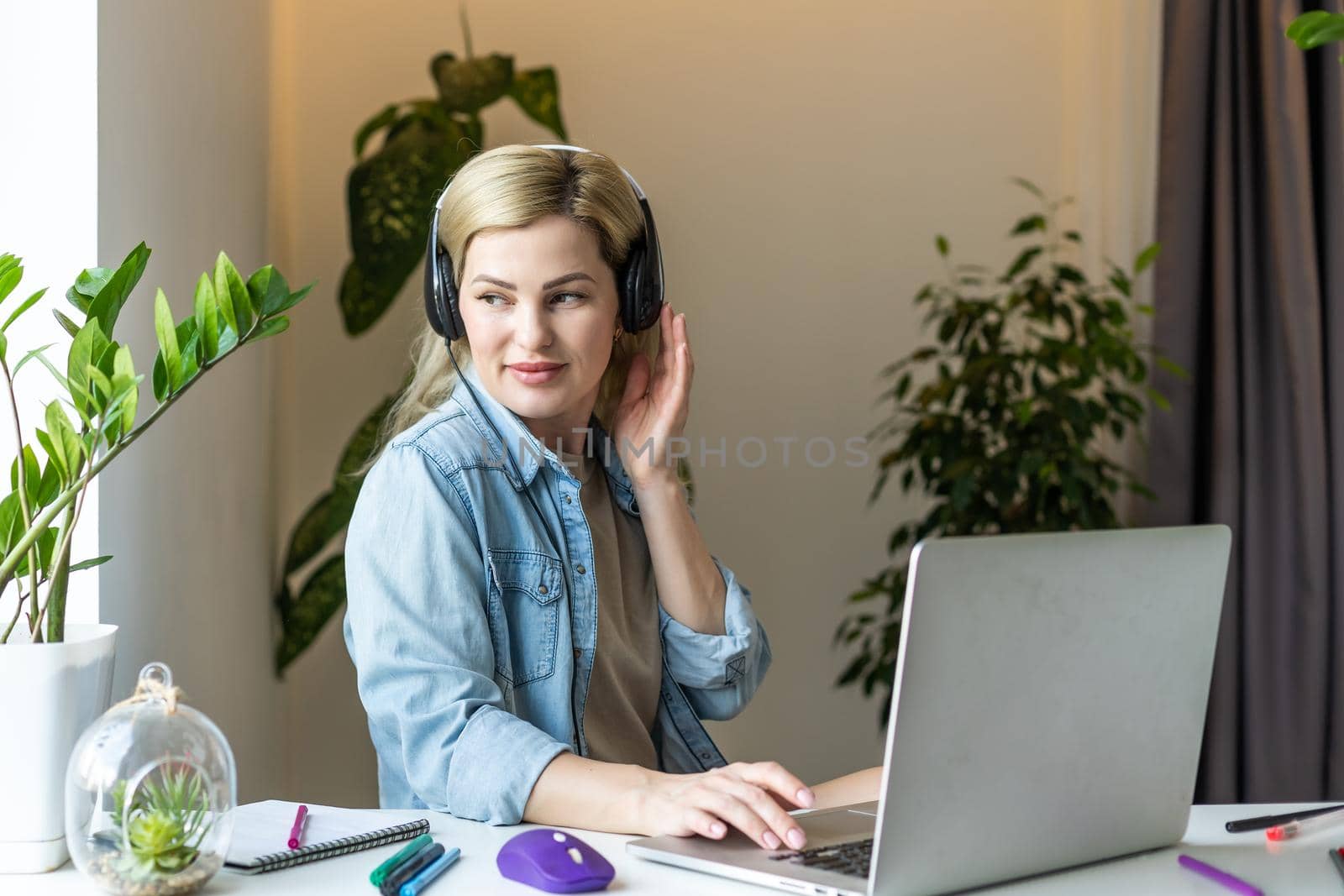 Pretty female student with cute smile keyboarding something on net-book while relaxing after lectures in University, beautiful happy woman working on laptop computer.