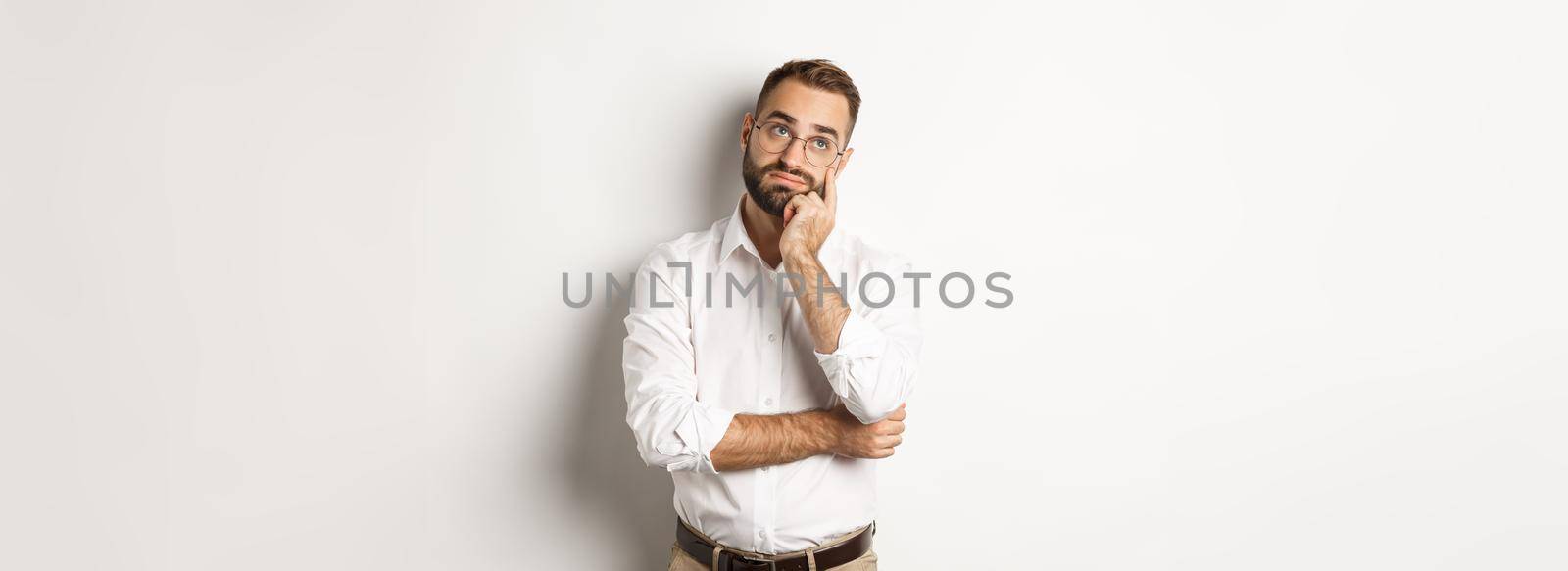 Troubled manage looking away thoughtful, feeling tired, standing over white background by Benzoix