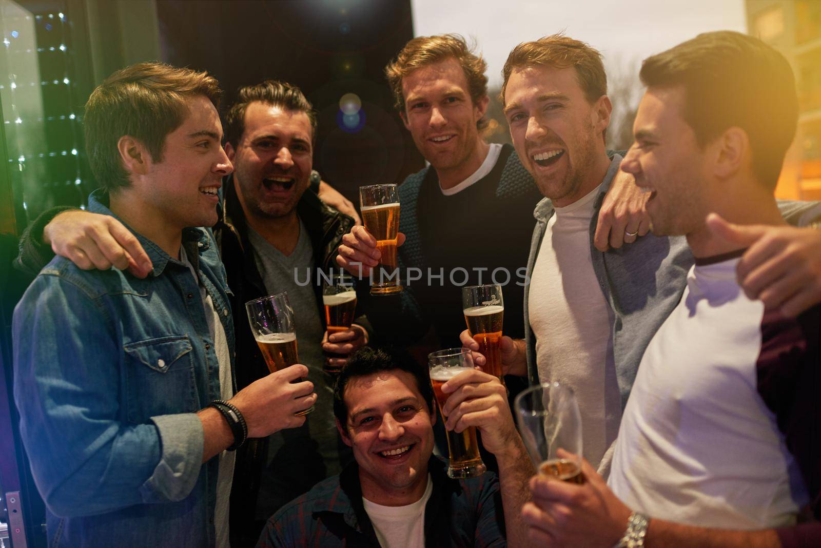 The boys are back in town. Cropped portrait of guys drinking beer at a party. by YuriArcurs