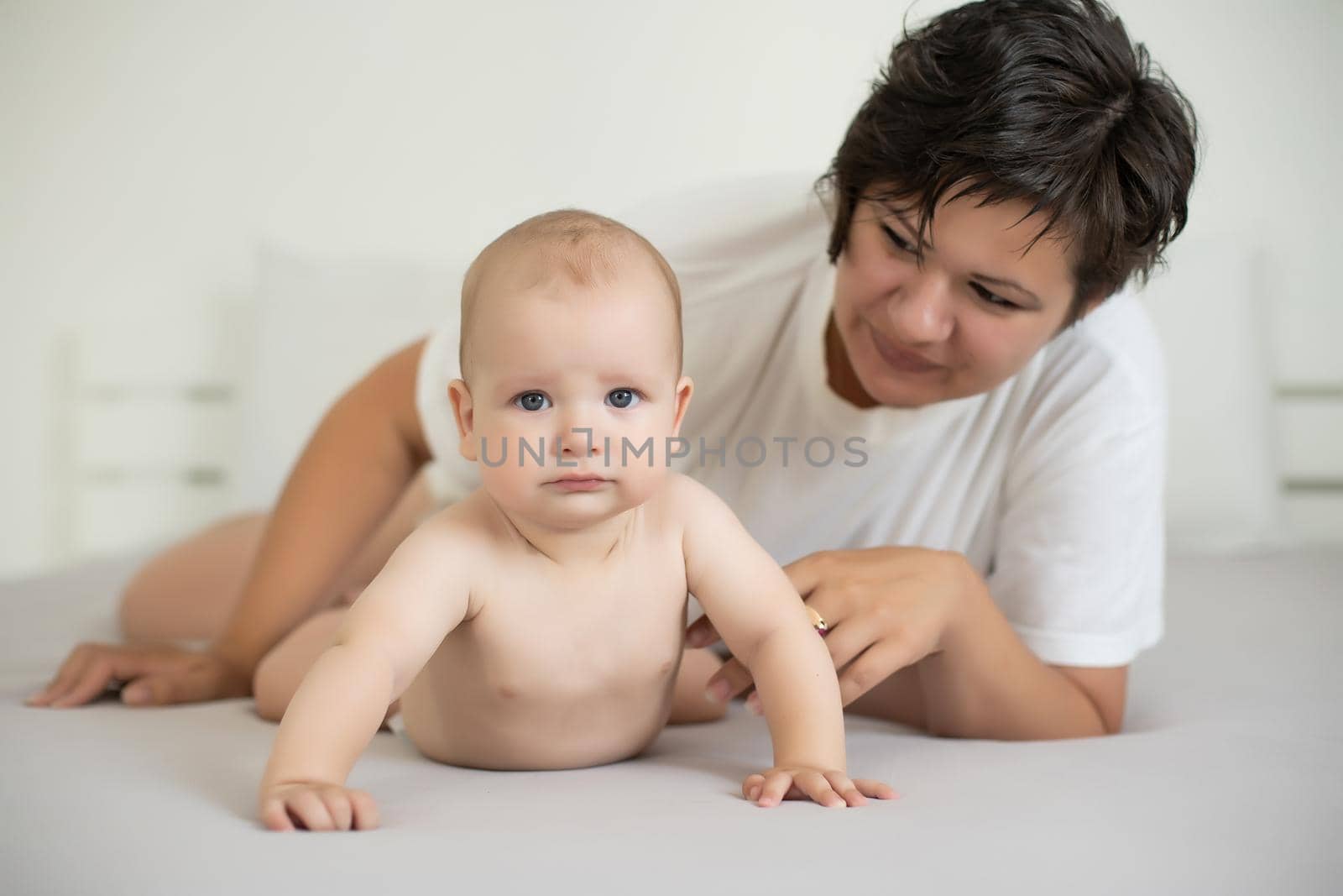 happy mother with baby on bed.