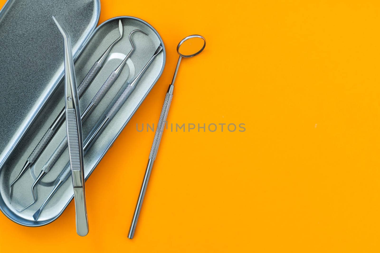 Dentist tools. Teethcare, dental health concept. orange background top view copy space.