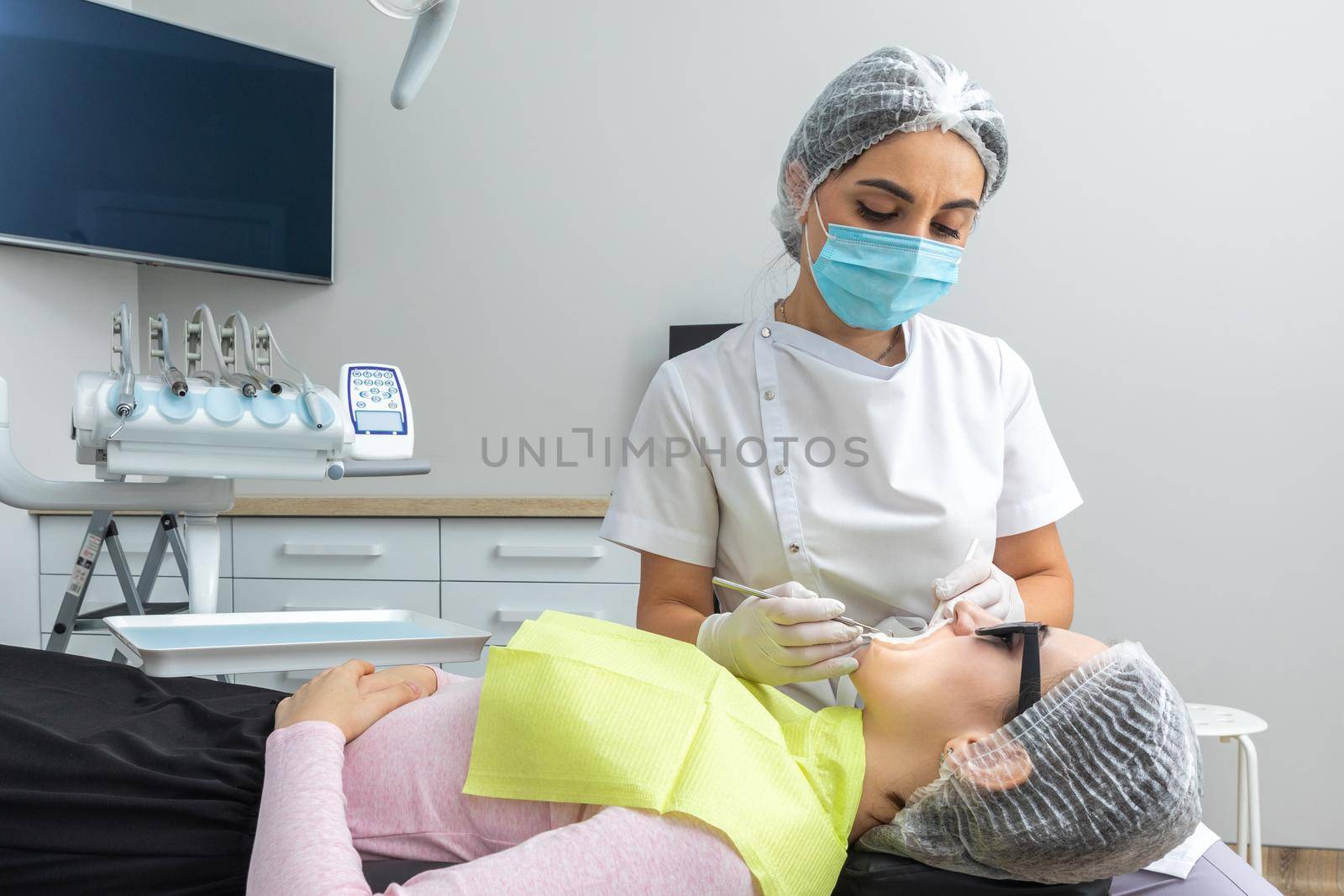 Dentist Examining Patient's Mouth with dental mirror In Clinic by Mariakray
