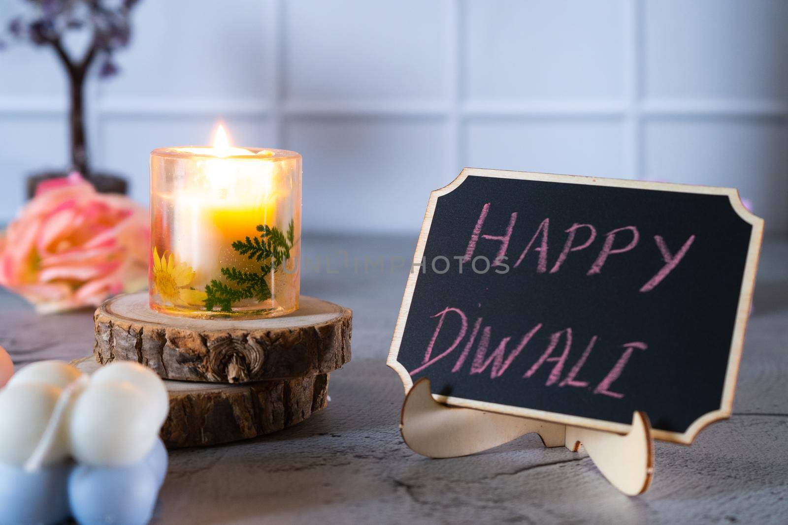 small transparent resin art candle lit with cute chalk board with happy diwali written on it for the festival of light by Shalinimathur