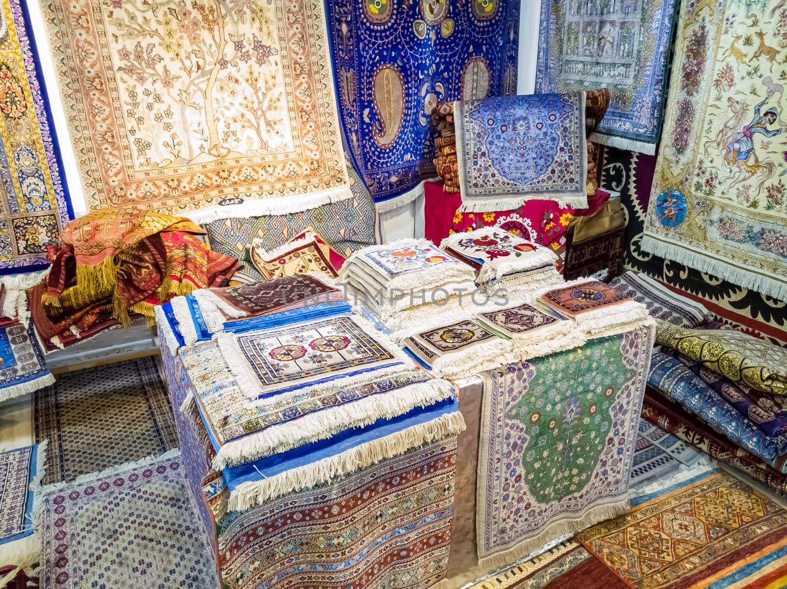 Ethnic carpet, ornamental folk bags, many ornate pillows with embroidery in asian shop, store. Asian market, trade fair in Uzbekistan. Traditional national ornament. Asian handicraft, Uzbek craft.