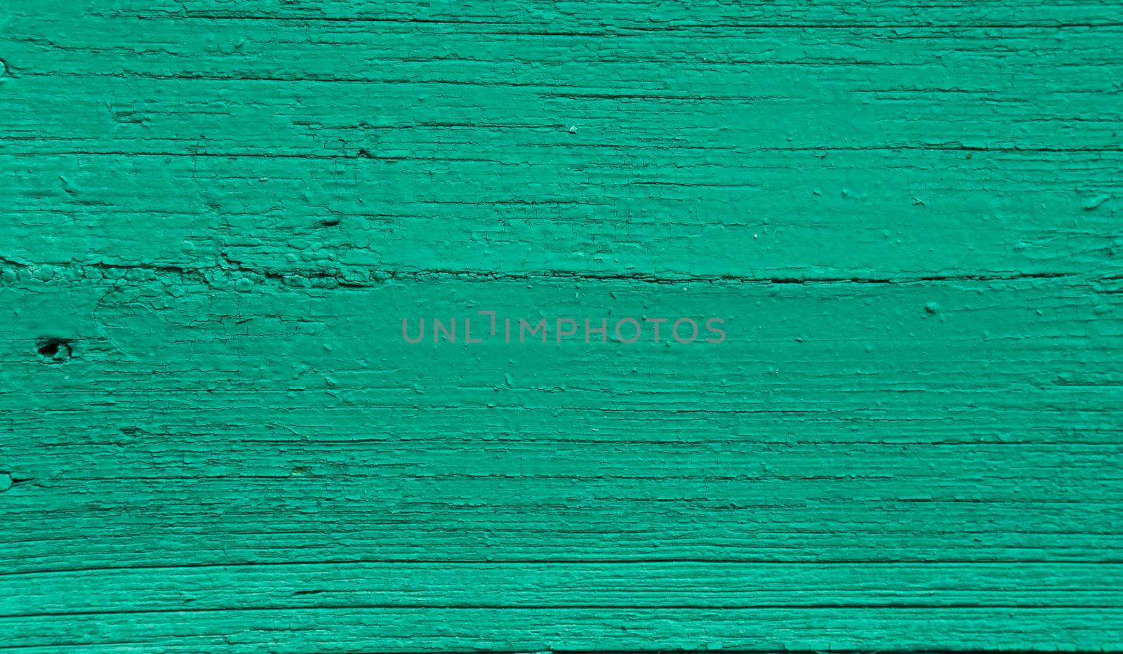 Vintage old green painted green wall background texture. The texture of an old time-damaged wooden board.