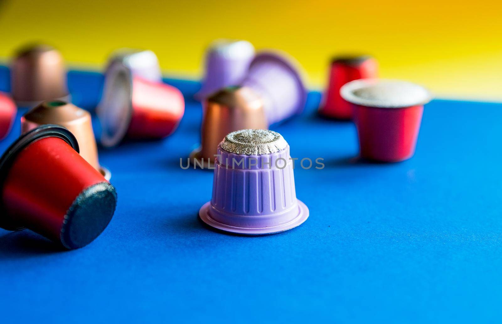 Cup of espresso coffee served with pods and capsules on brown wooden table. Top view