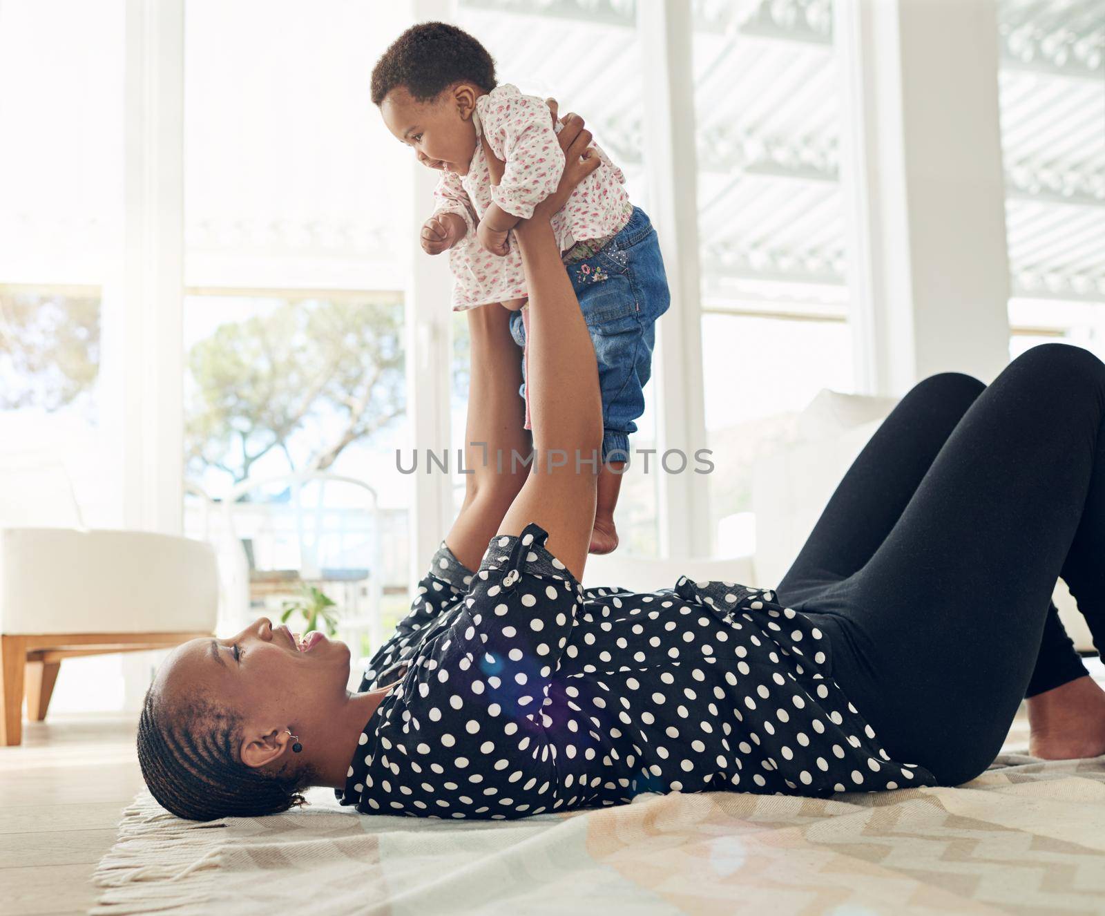 The most important person in her life. a mother holding her baby girl up in the air
