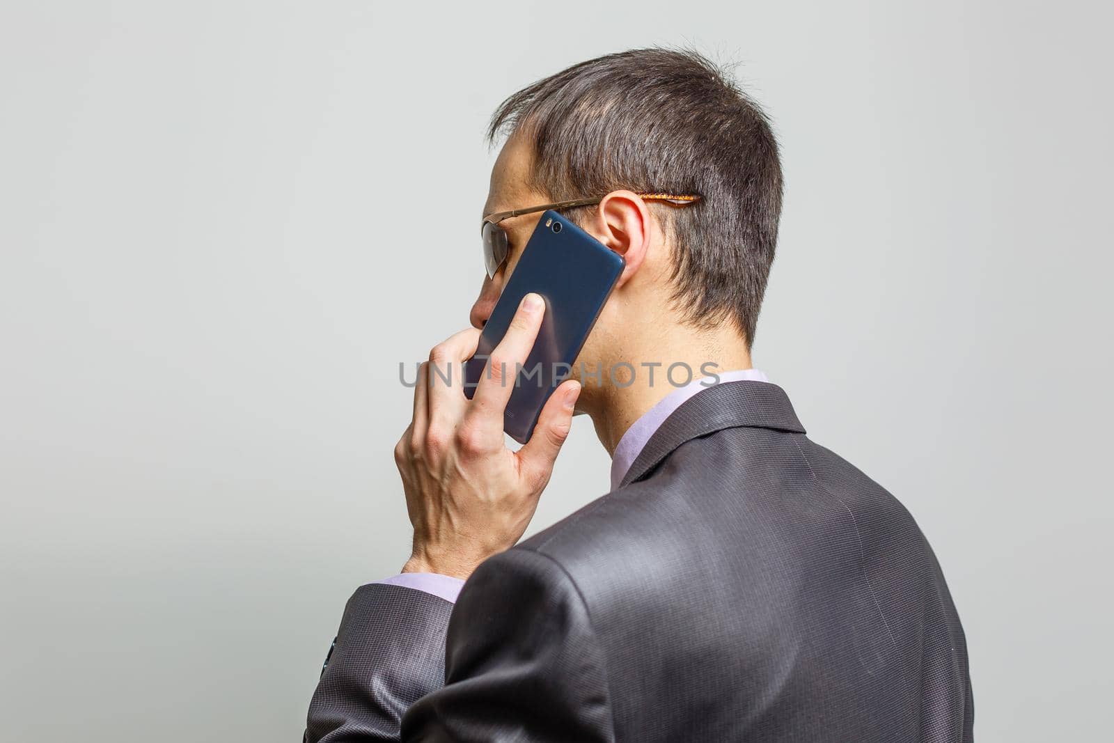 Cool businessman standing on grey background