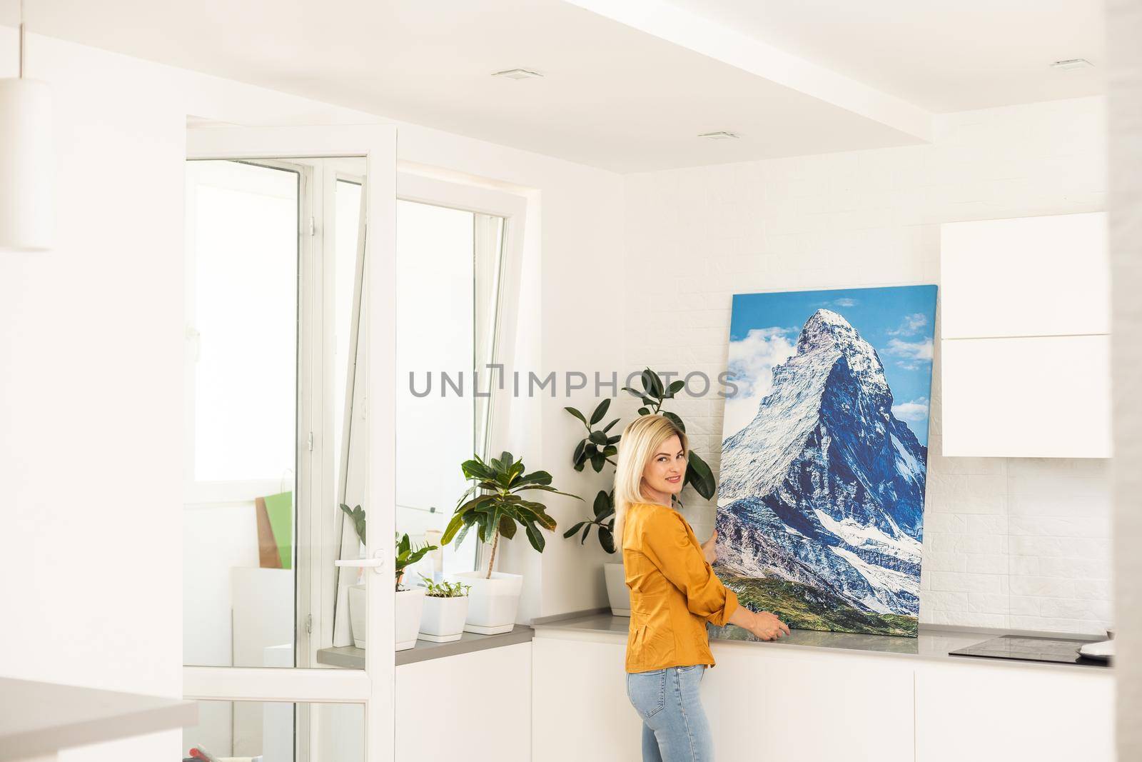 Woman hanging a photo canvas on a wall