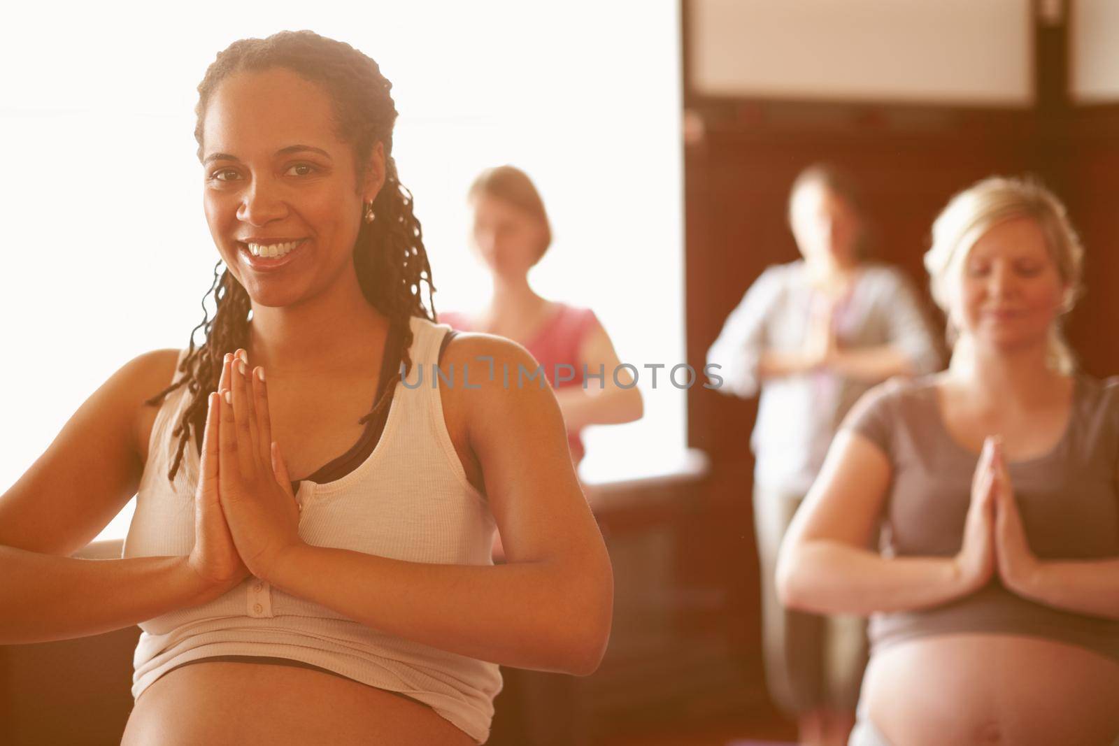 Yoga, wellness and meditation of pregnant women with prayer hands sign for spiritual, calm and healthy lifestyle. Happy personal trainer meditate in yoga class, welcome smile in a zen studio portrait by YuriArcurs
