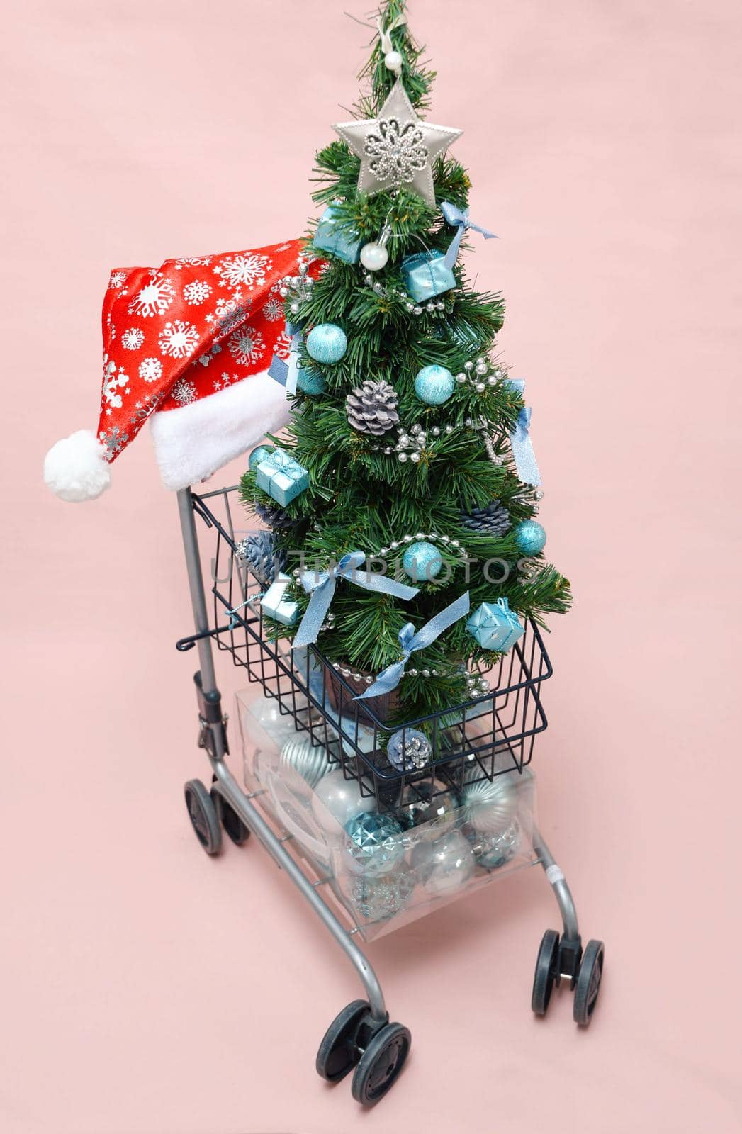 Christmas artificial mini tree with blue balls in shopping carts, new year shopping. High quality photo