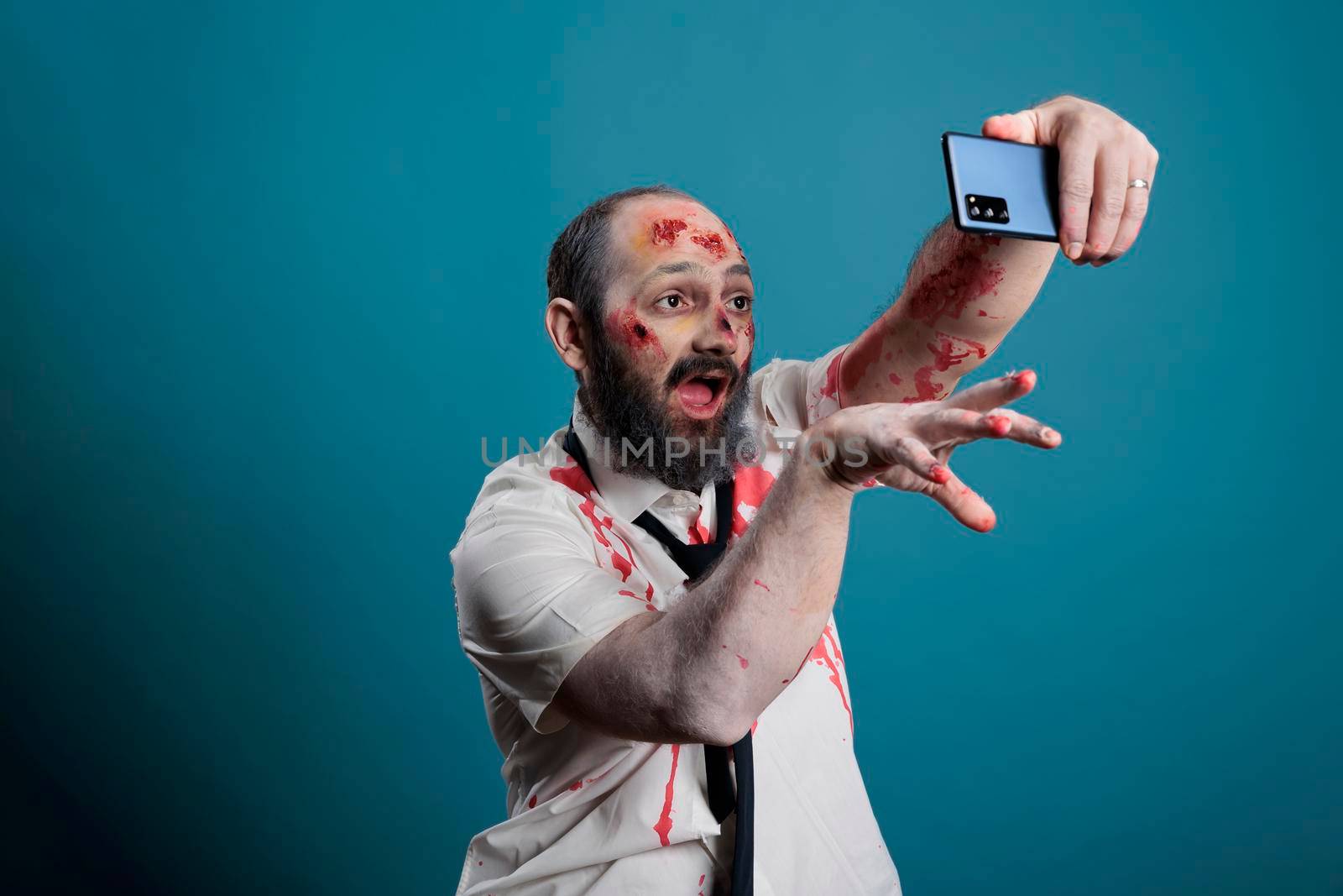 Crazy halloween monster taking photo on smartphone by DCStudio