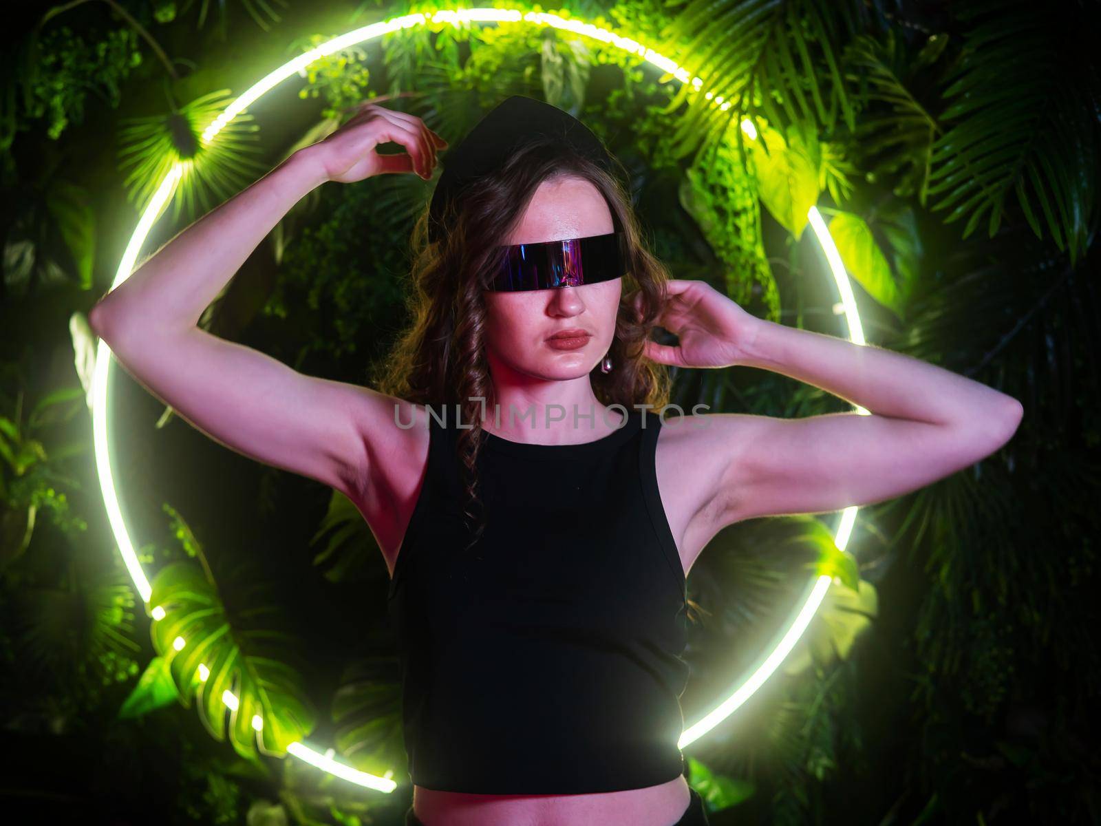 Caucasian woman in panoramic sunglasses against the background of an annular neon lamp in plants. by mrwed54