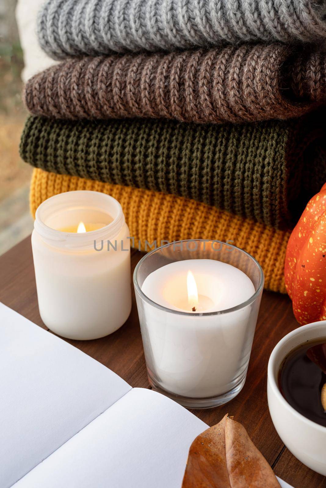 High angle view autumn composition with sweaters and candles, mockup design by Desperada