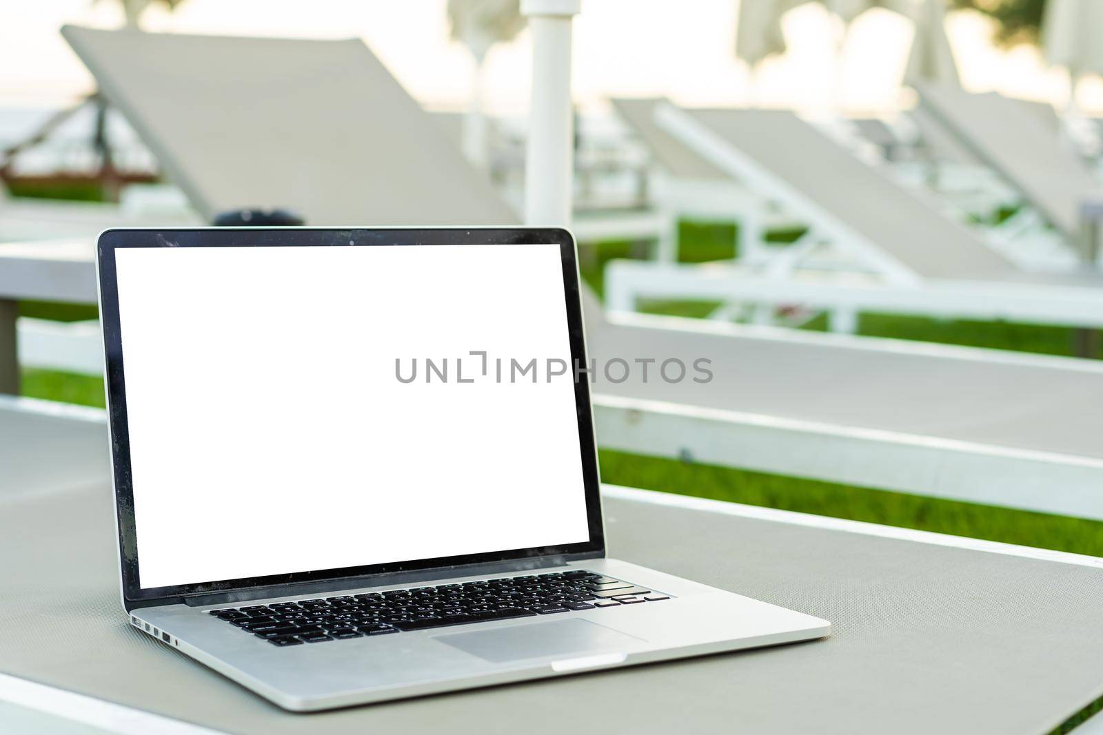 Computer laptop with blank screen near the swimming pool