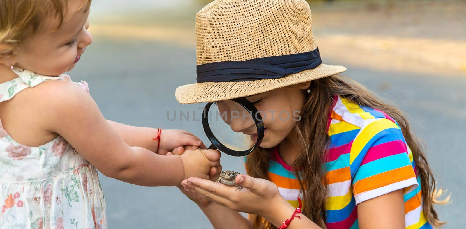 The child is playing with the frog. Selective focus. by yanadjana