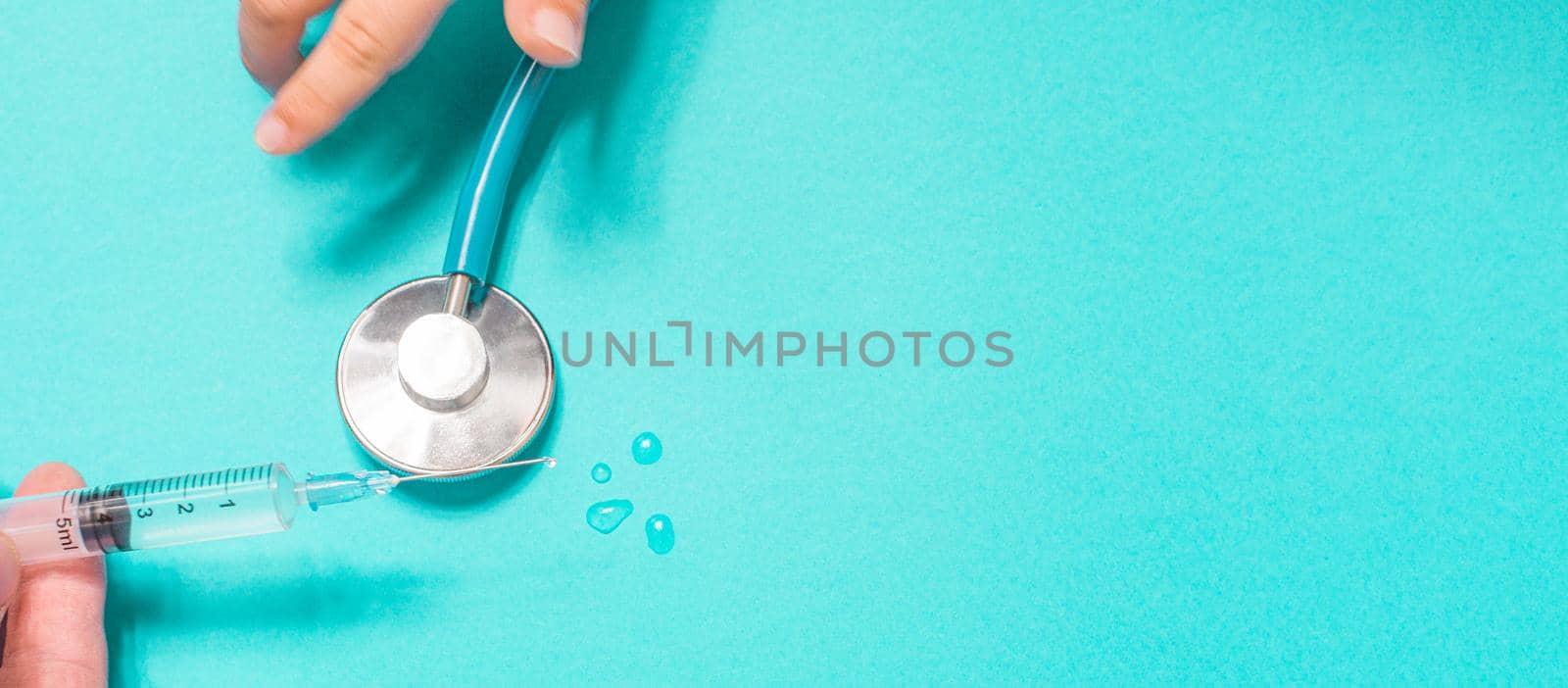 Syringe with vaccine on blue background from above by Ciorba