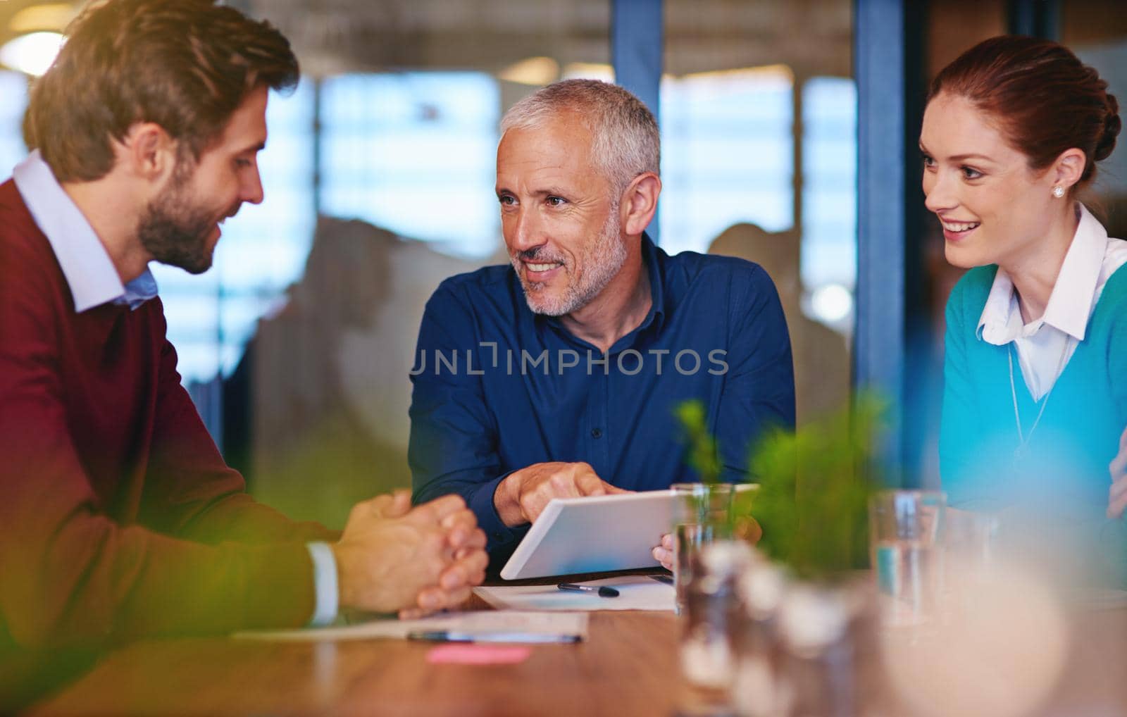 Developing a plan of action. businesspeople using a digital tablet in a meeting