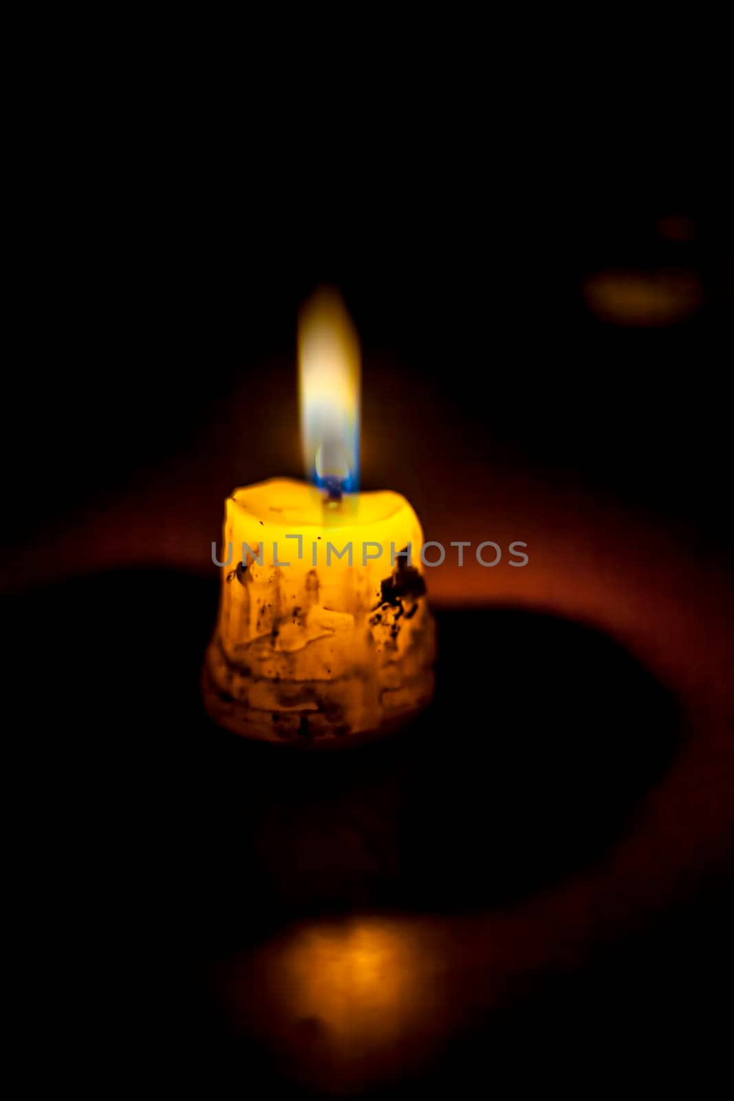 Shot of a single isolated candle burning itself and giving light to its surrounding.