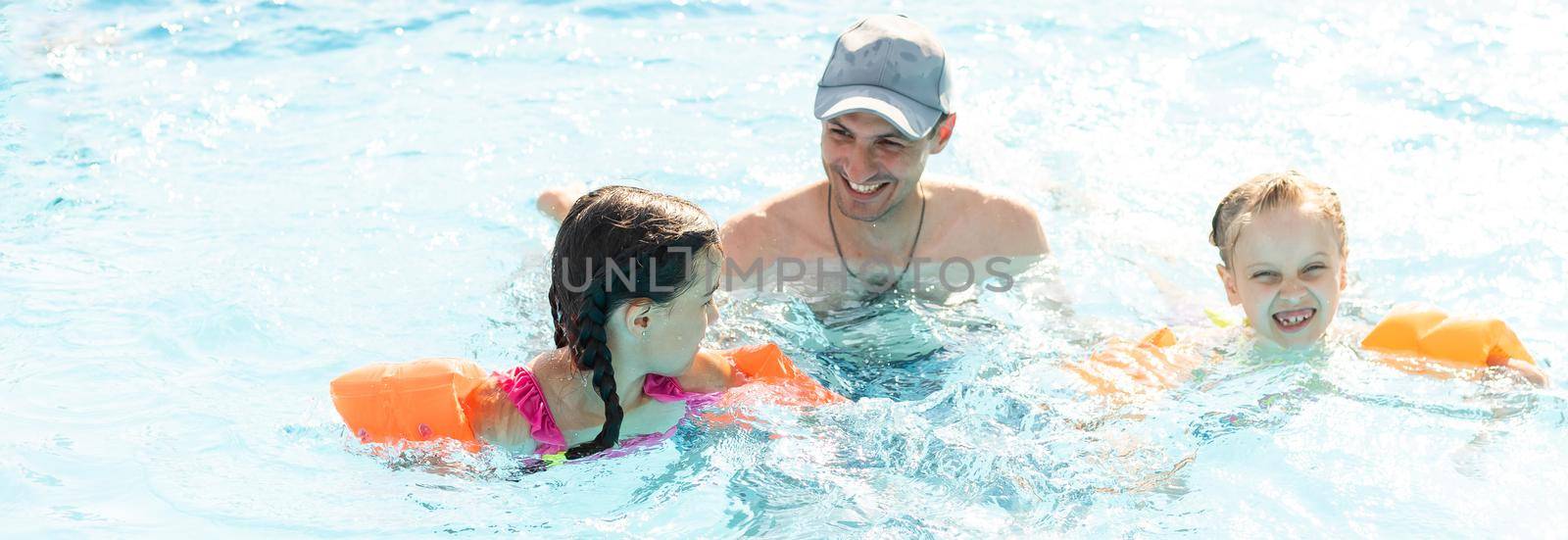 Happy family playing in swimming pool. Summer vacation concept by Andelov13