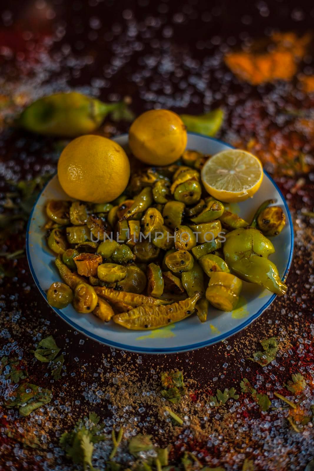 Close up shot of traditional ivy gourd or tindora salad in a glass plate with all of its constituent ingredients with it on a brown colored wooden surface.