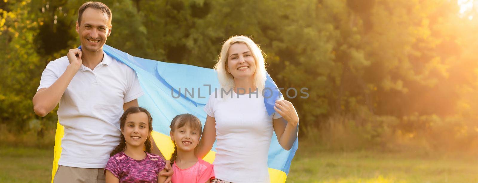 Happy family s with flag of Ukraine in field