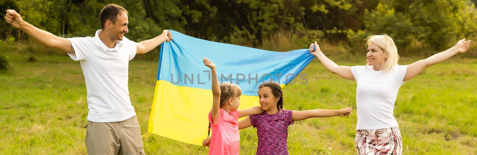 Flag Ukraine in hands of little girl in field. Child carries fluttering blue and yellow flag of Ukraine against background field. by Andelov13