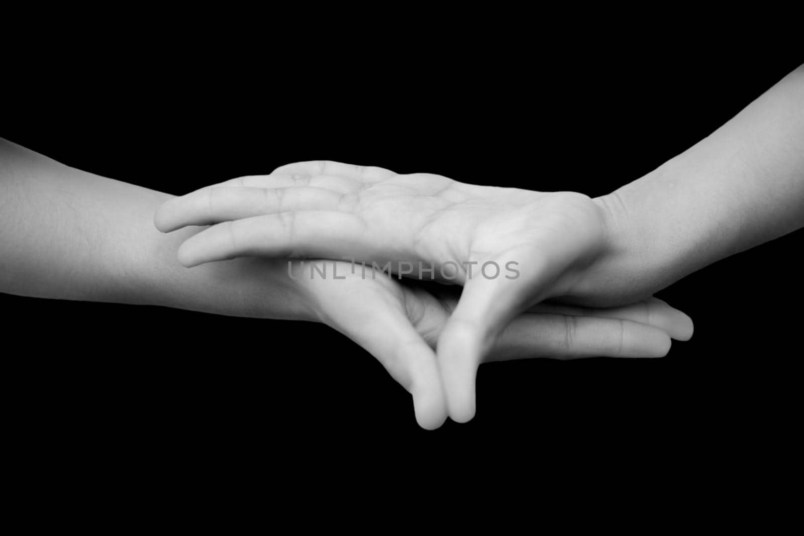 Shot of male hands isolated on black background demonstrating Buddha Mudra.