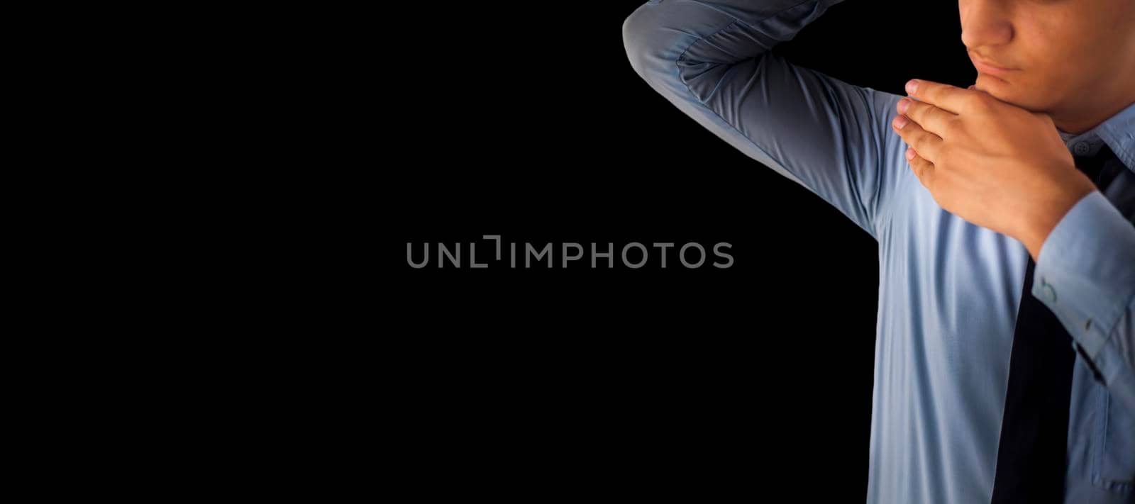 Close up shot of a male in businesswear and holding his chin isolated on black background.