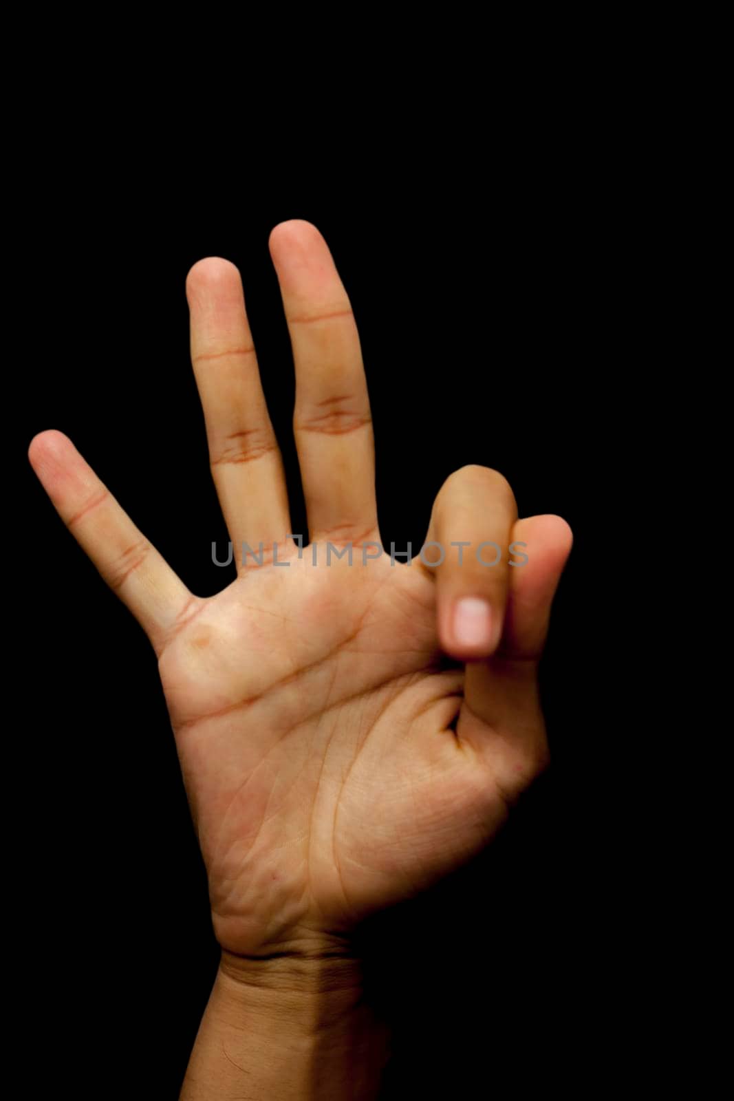 Shot of single hands doing Gyan mudra isolated on black background. by mirzamlk