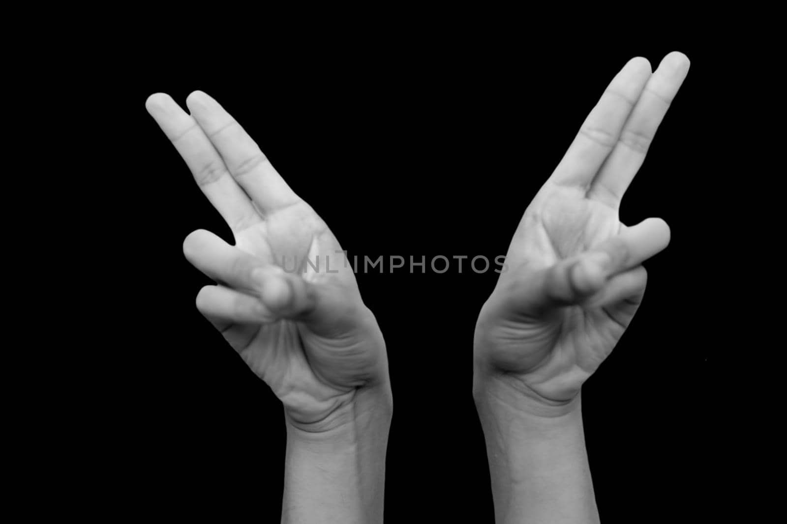 Shot of pair of hands doing Kapitthaka Mudra or Smiling Buddha Mudra isolated on black background. by mirzamlk