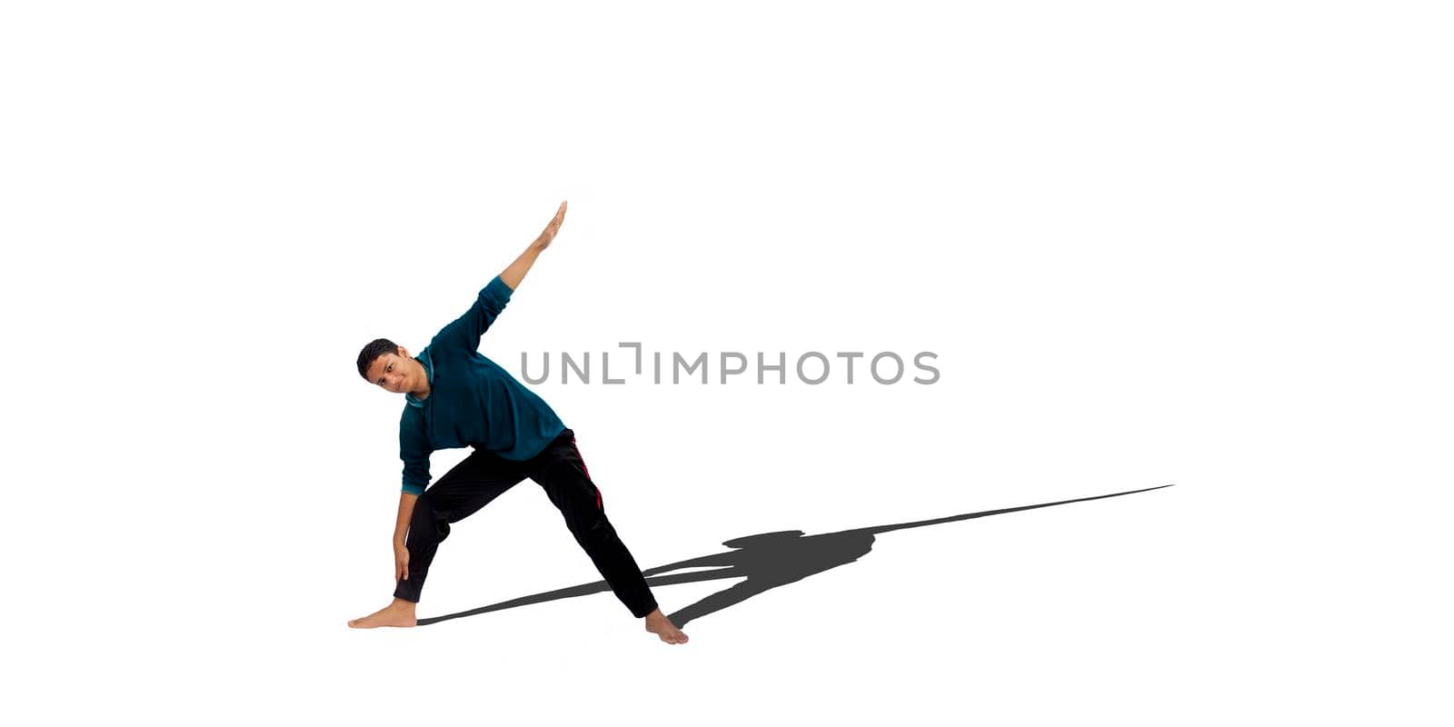 Full body shot of a young male teenager in activewear doing warm up exercise isolated on white background.