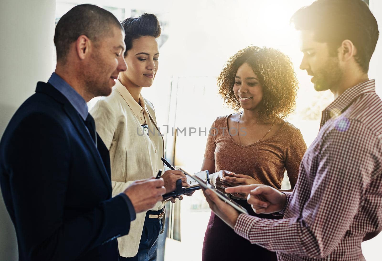 Teamwork makes success easier. a group of colleagues using a tablet while meeting in the boardroom