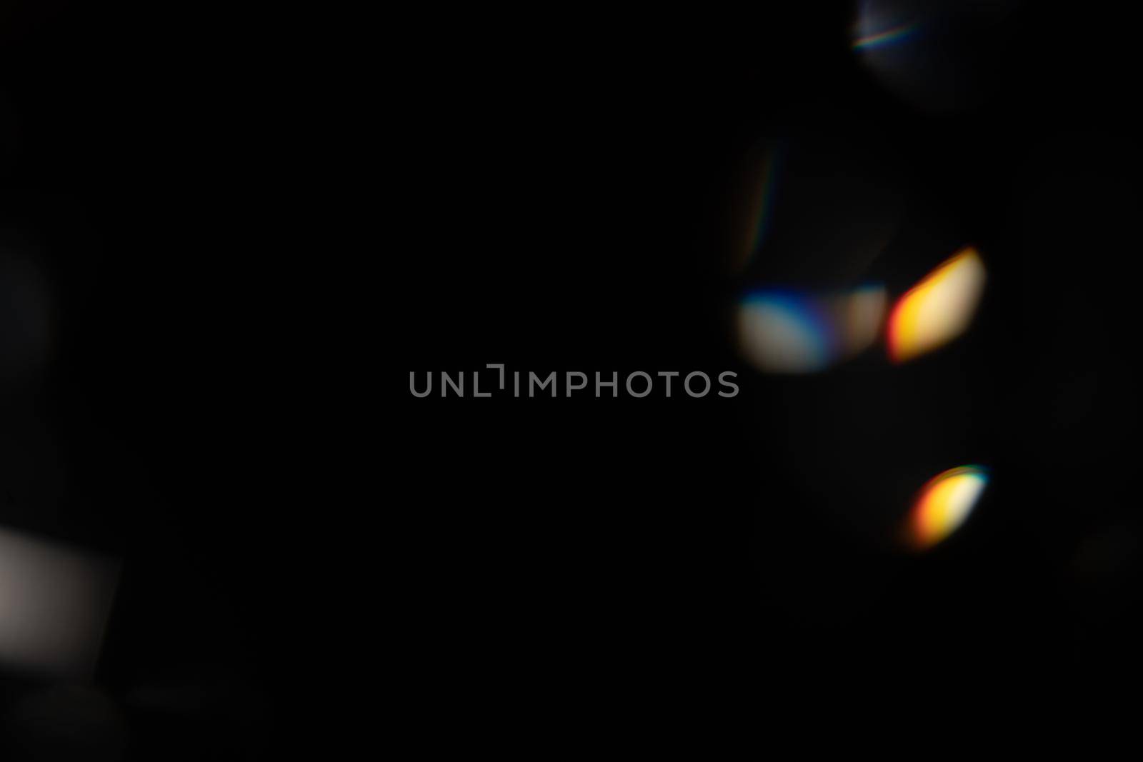 Blue light flare prism rainbow flares overlay effect on black background, light crossing crystals, prismatic sun catcher reflections rays. Abstract blurred colourful lens flare bokeh on dark by photolime