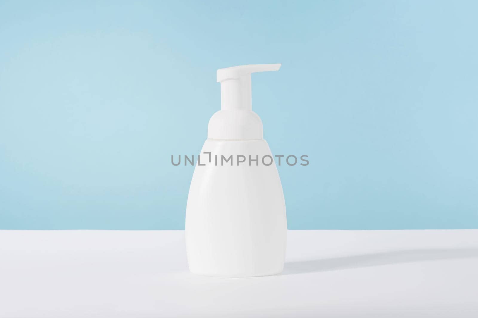 Bath soap white cosmetic bottle mockup on blue background. Body care product or lotion packaging. Plastic cosmetics tube front view advertising mock up. Body hygiene cream, wellness concept