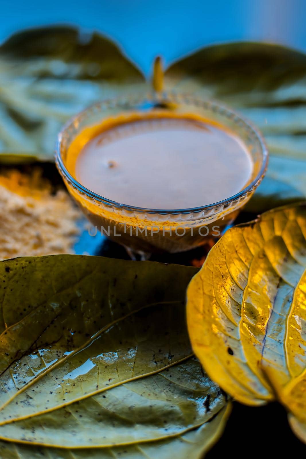 Face mask for nourishing your skin consisting of betel leaves, besan or chickpea powder, Multani mitti, or mulpani mitti on a black surface. by mirzamlk