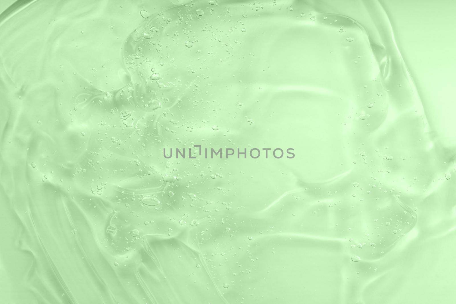 Liquid green oil smudge. The concept of natural cosmetics. Hyaluronic acid clear serum sample. Aloe vera cosmetic gel texture with bubbles background. by photolime